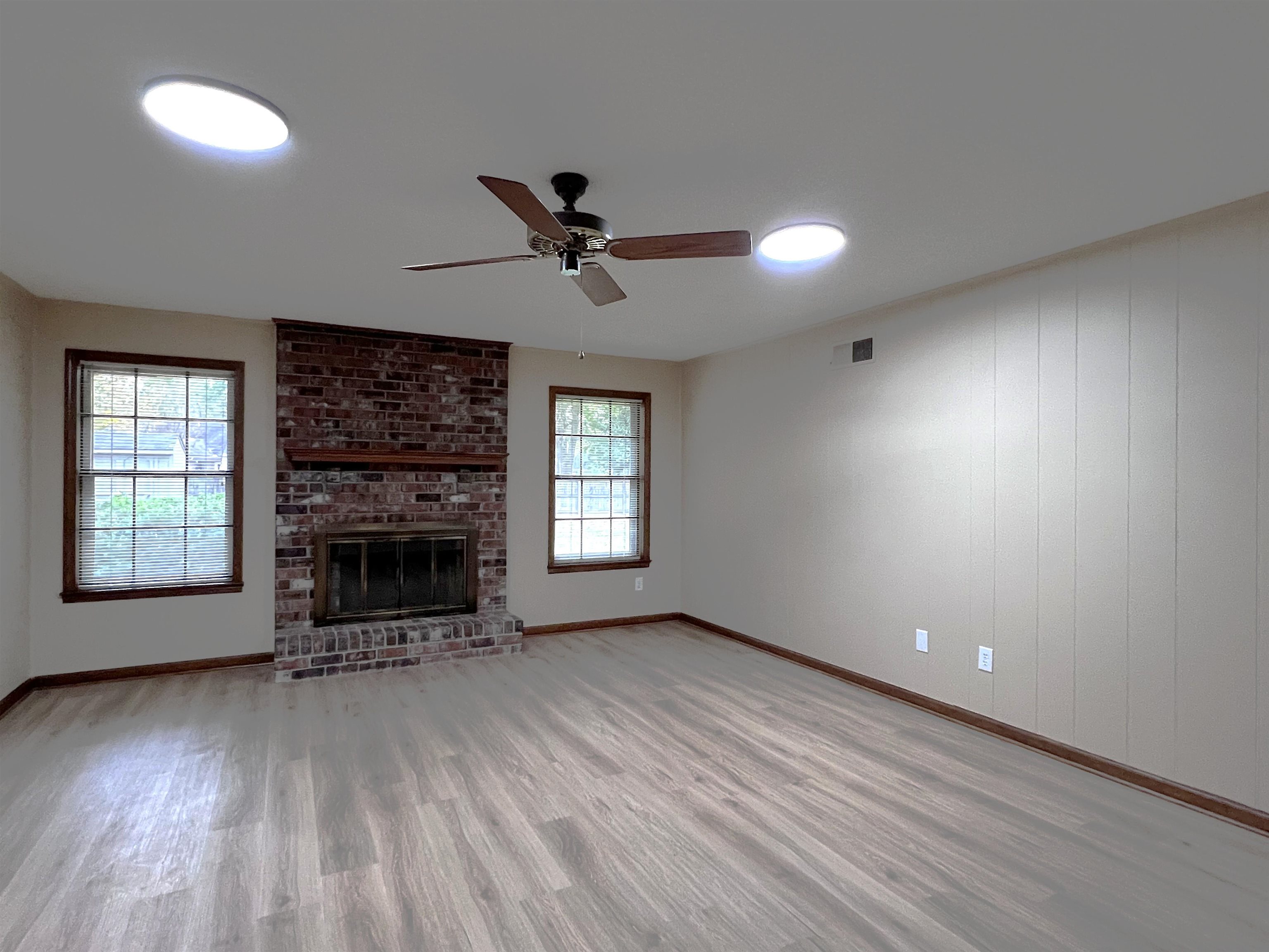 309 West Powell Road Collierville, TN 38017 - Photo 13 of 40 an empty room with windows fireplace and wooden floor