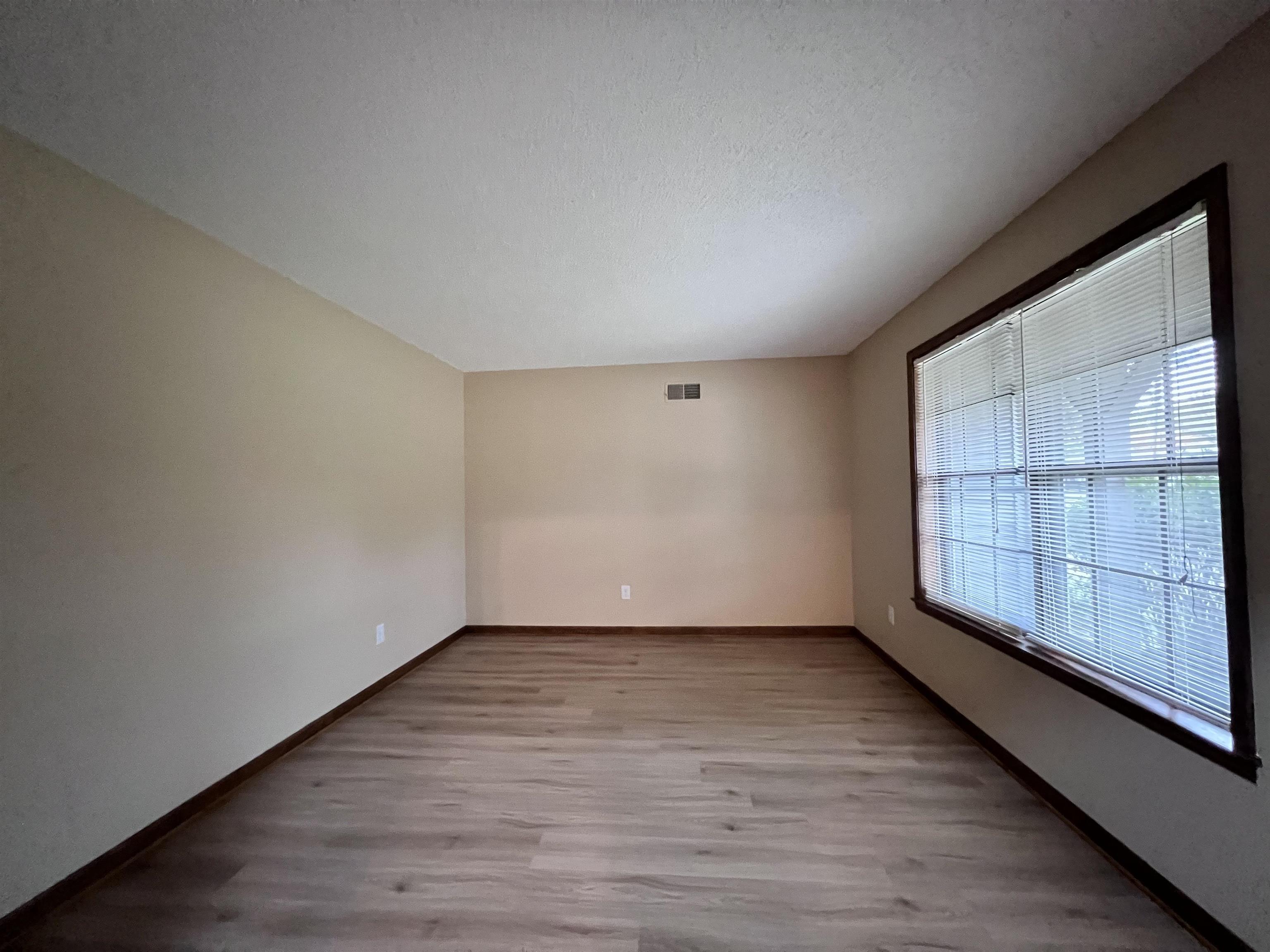 309 West Powell Road Collierville, TN 38017 - Photo 16 of 40 a view of an empty room with wooden floor and windows