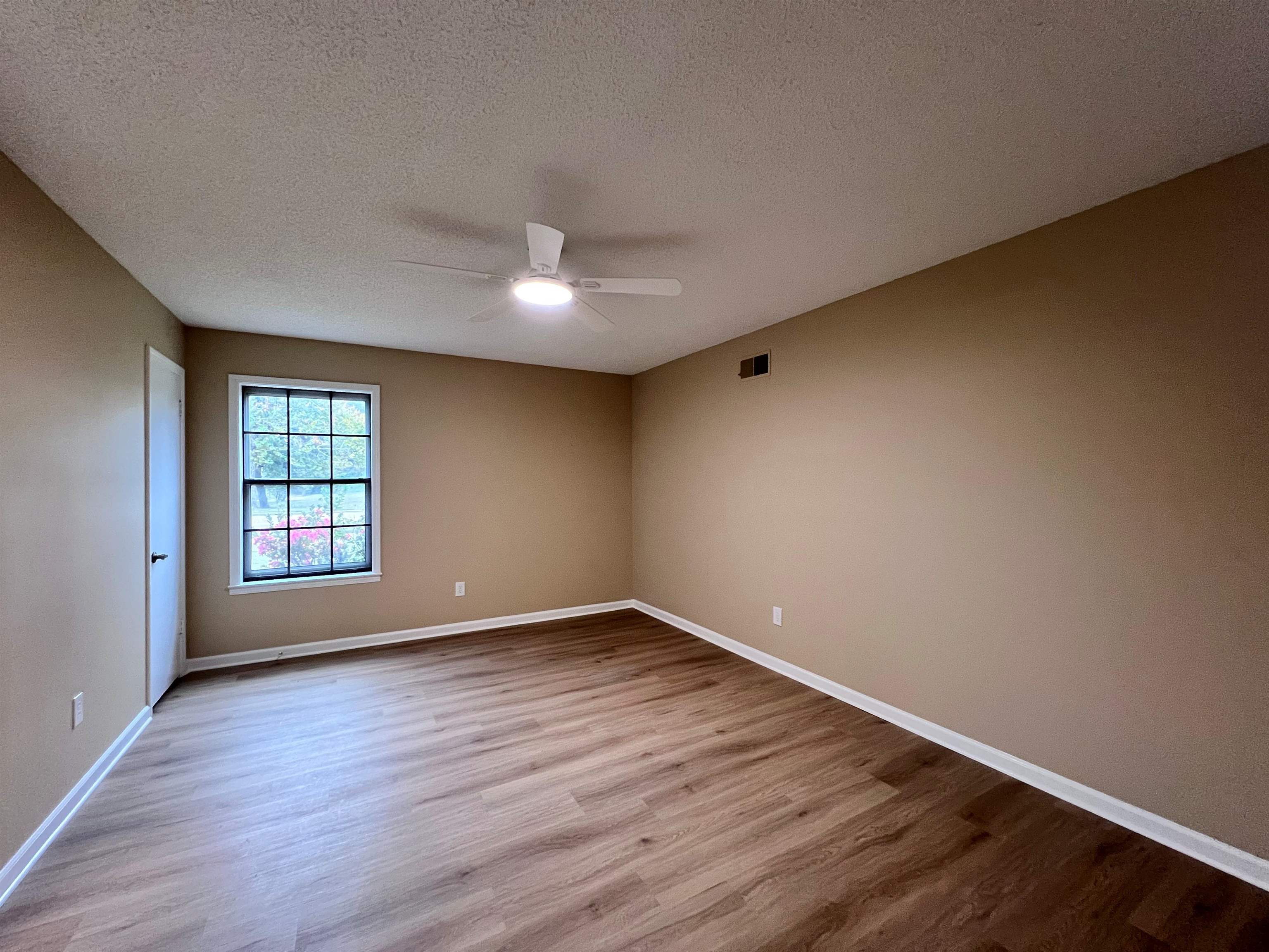 309 West Powell Road Collierville, TN 38017 - Photo 17 of 40 a view of an empty room with wooden floor and fan