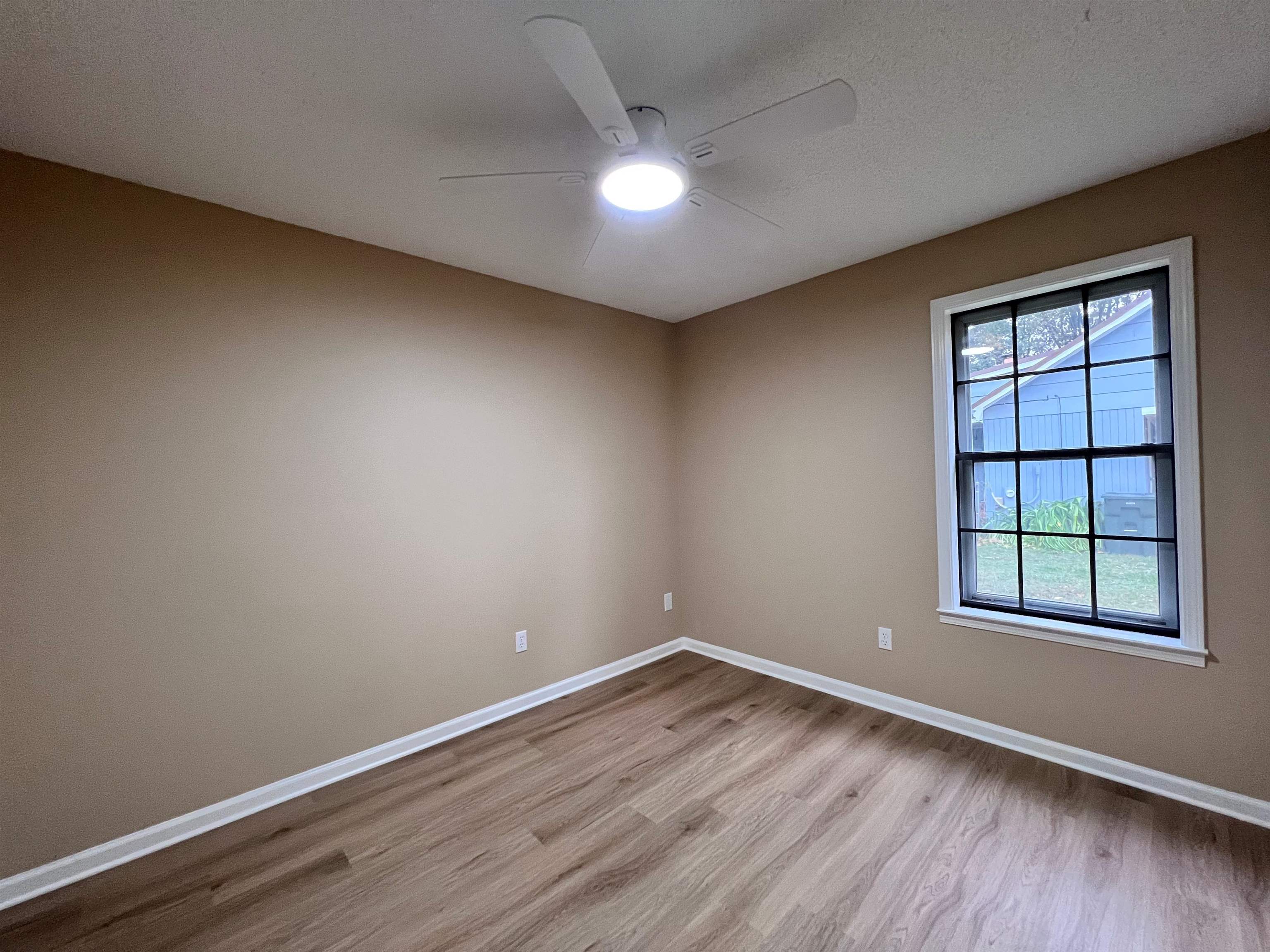 309 West Powell Road Collierville, TN 38017 - Photo 24 of 40 an empty room with wooden floor and windows