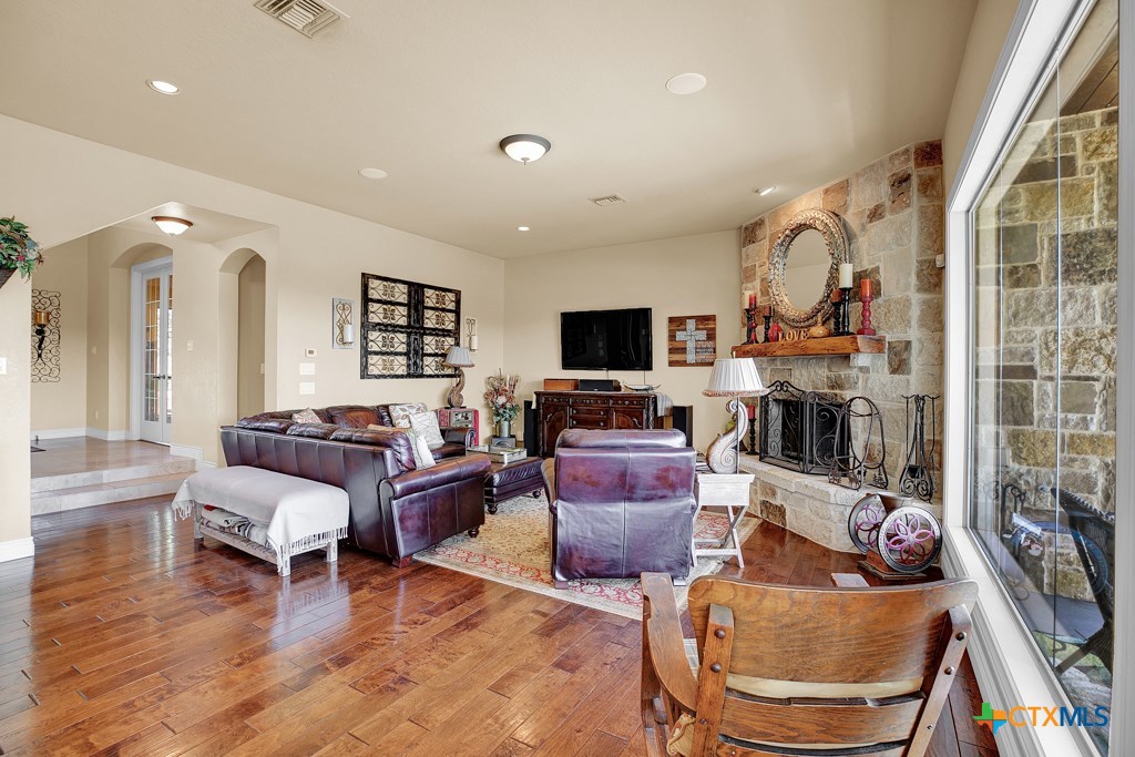 1262 Elm Creek Road New Braunfels, TX 78132 - Photo 11 of 48 a living room with furniture a fireplace and a flat screen tv