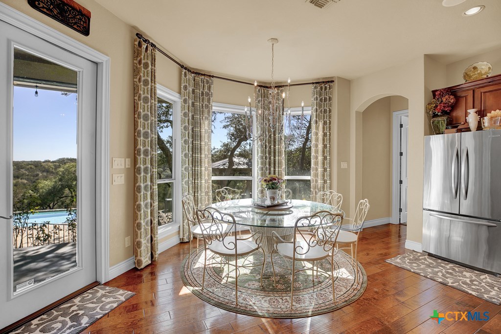 1262 Elm Creek Road New Braunfels, TX 78132 - Photo 12 of 48 a view of a dining room with furniture a chandelier and wooden floor