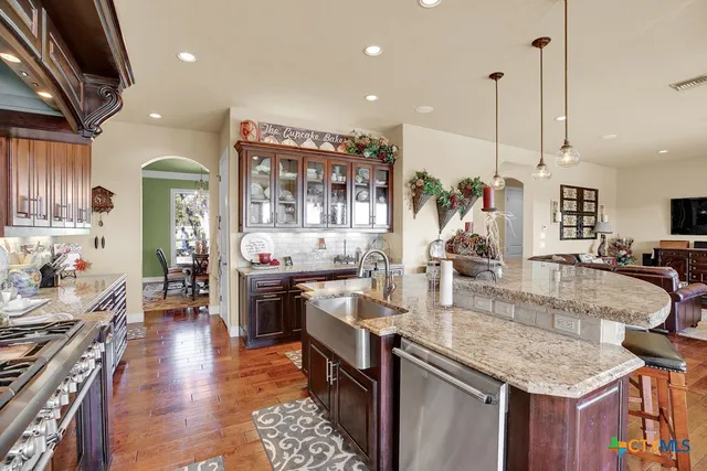 a kitchen with lots of counter top space a sink appliances and cabinets