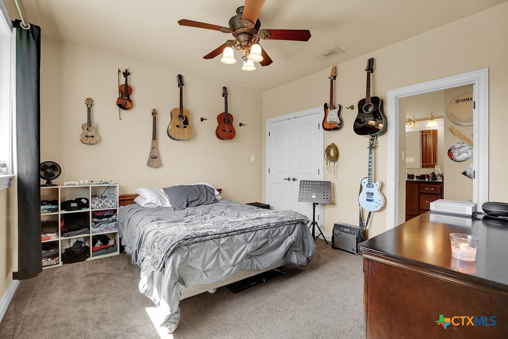 1262 Elm Creek Road New Braunfels, TX 78132 - Photo 33 of 48 a bedroom with a bed and a chandelier