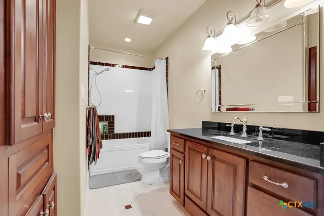 a bathroom with a sink a toilet a mirror and shower