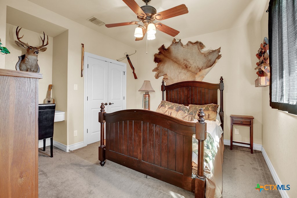 1262 Elm Creek Road New Braunfels, TX 78132 - Photo 35 of 48 a bedroom with a bed and a chandelier