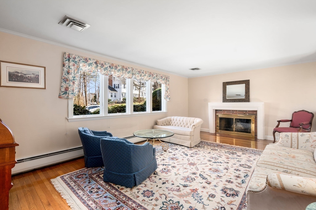 3 Tower Road Lexington, MA 02421 - Photo 10 of 38 a living room with furniture a fireplace and a table