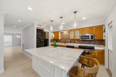 a kitchen with stainless steel appliances granite countertop a sink and a refrigerator