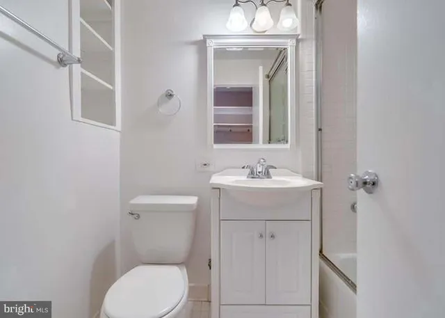 a bathroom with a toilet a sink and mirror