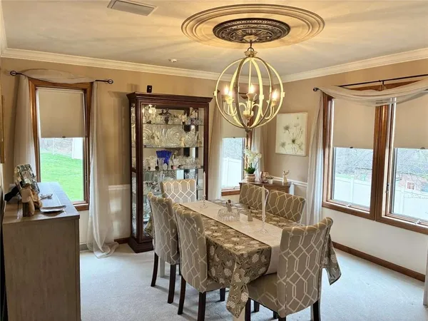 a dining room with furniture a chandelier and wooden floor