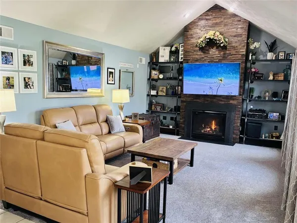 a living room with furniture a flat screen tv and a fireplace