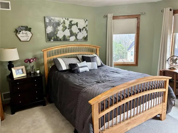 a bed sitting in a bedroom next to a window