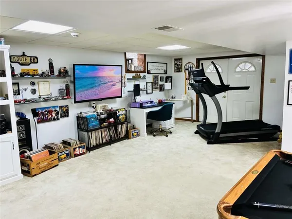 a room with gym equipment and a flat screen tv