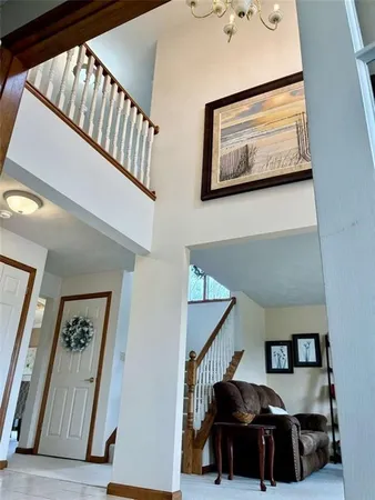 a view of staircase with lots of frames on wall and a painting