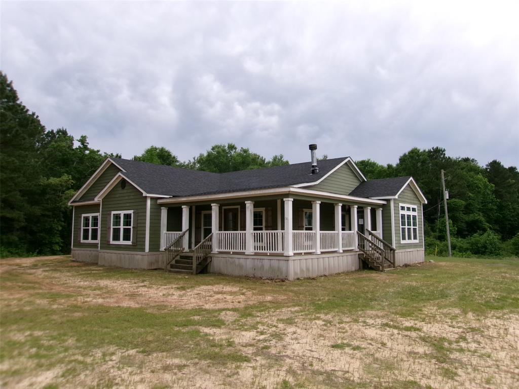 a front view of a house with a garden and trees