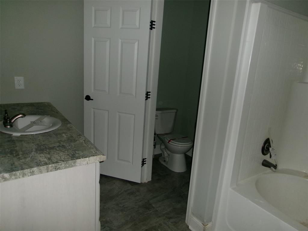 810 Williams Road Converse, LA 71419 - Photo 10 of 15 a bathroom with a granite countertop sink and a toilet