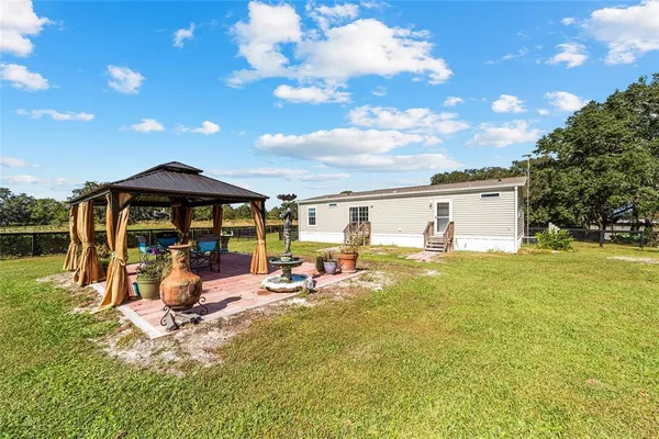 a kitchen with stainless steel appliances granite countertop a refrigerator a stove and a sink with wooden floor