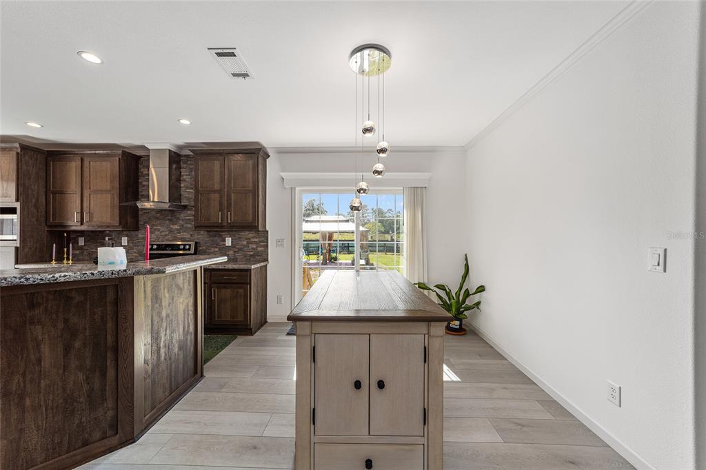4520 Northwest 95th Avenue Road Ocala, FL 34482 - Photo 15 of 87 a kitchen with stainless steel appliances kitchen island granite countertop a stove a sink and a refrigerator