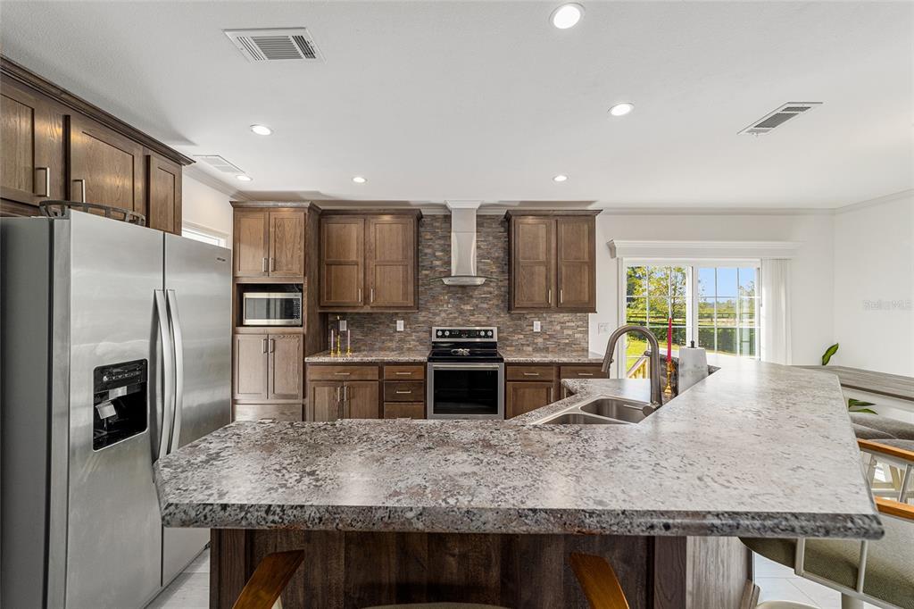 4520 Northwest 95th Avenue Road Ocala, FL 34482 - Photo 16 of 87 a kitchen with kitchen island granite countertop a large counter top stainless steel appliances a sink and cabinets