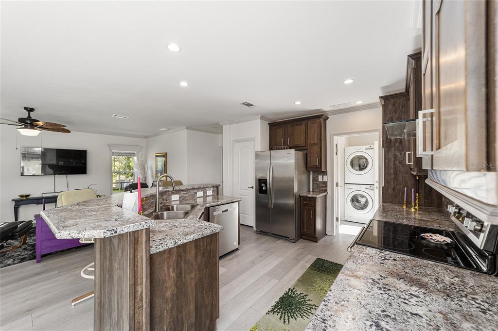 4520 Northwest 95th Avenue Road Ocala, FL 34482 - Photo 17 of 87 a kitchen with stainless steel appliances granite countertop a refrigerator a stove and a sink with wooden floor