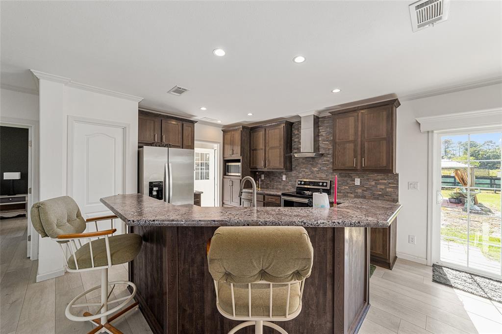 4520 Northwest 95th Avenue Road Ocala, FL 34482 - Photo 18 of 87 a kitchen with granite countertop kitchen island stainless steel appliances a sink and counter space