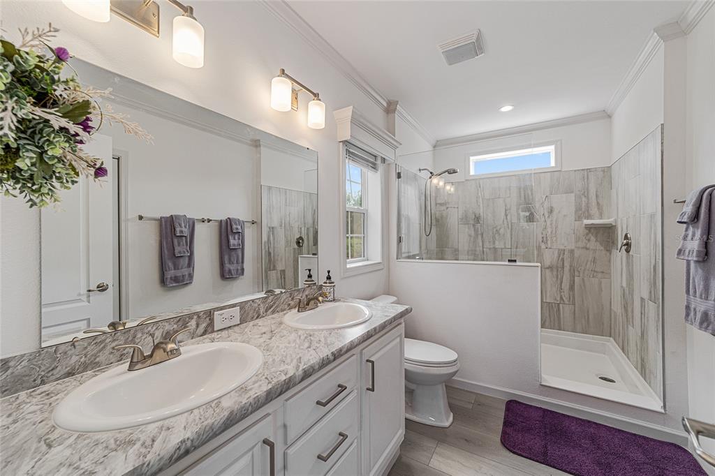 4520 Northwest 95th Avenue Road Ocala, FL 34482 - Photo 25 of 87 a bathroom with a granite countertop sink toilet and shower