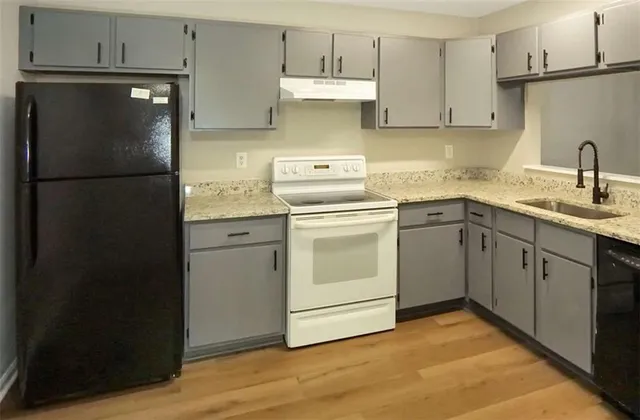 a kitchen with a refrigerator sink and cabinets