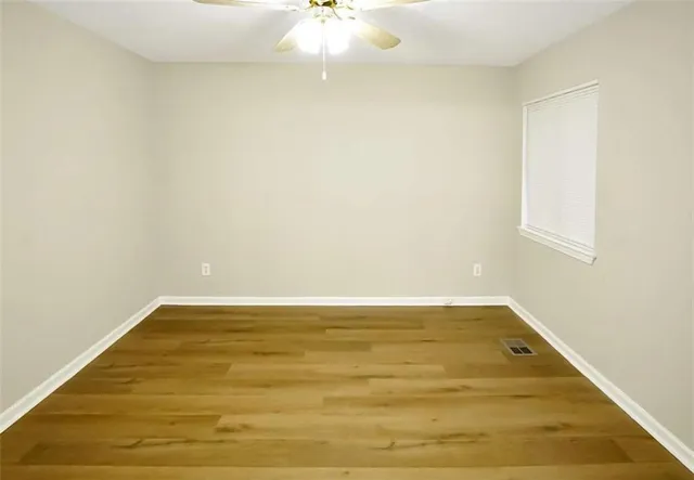 a view of a room with wooden floor and a ceiling fan