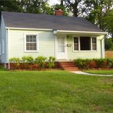 a front view of a house with a yard and garden