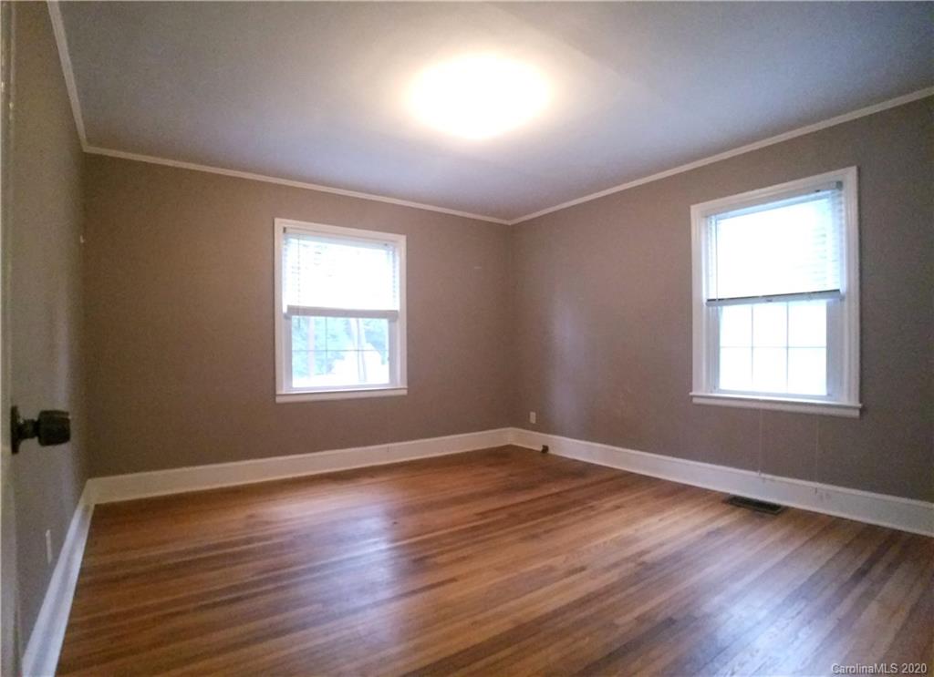 1900 Arnold Drive Charlotte, NC 28205 - Photo 15 of 23 an empty room with wooden floor and windows