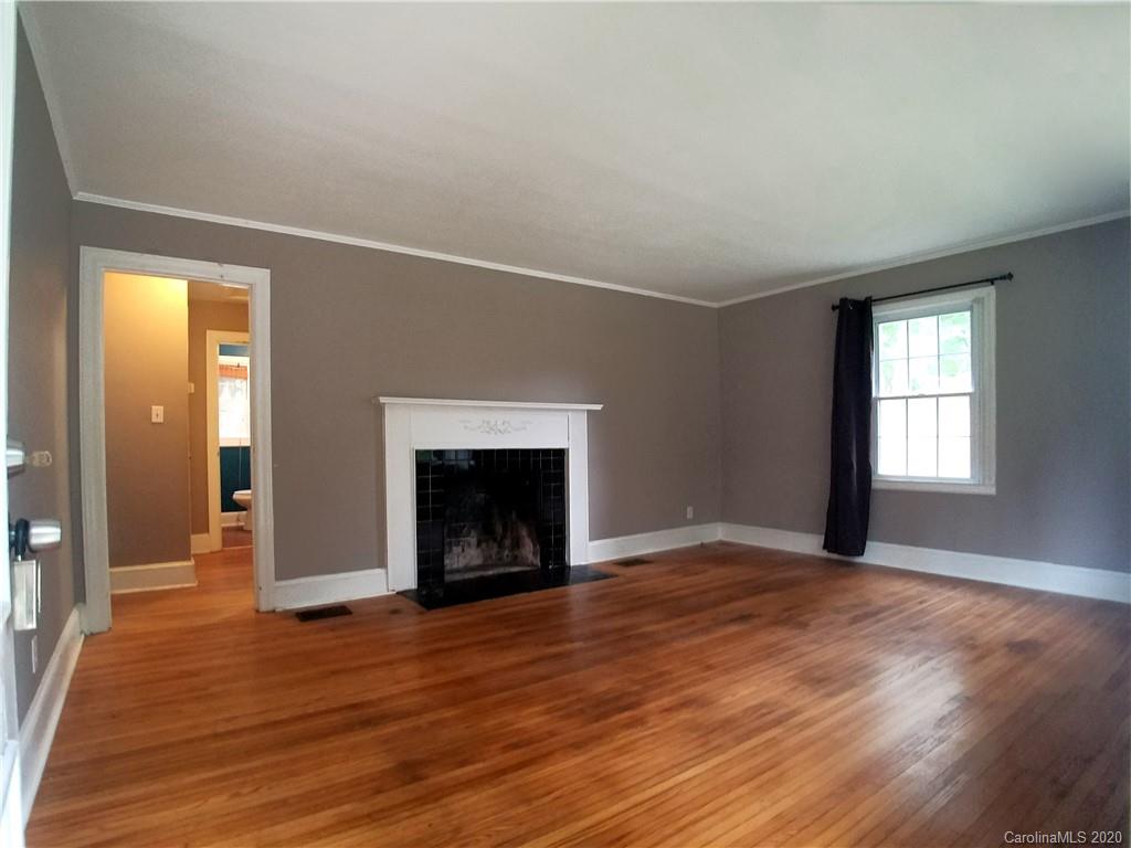 1900 Arnold Drive Charlotte, NC 28205 - Photo 6 of 23 an empty room with wooden floor fireplace and windows