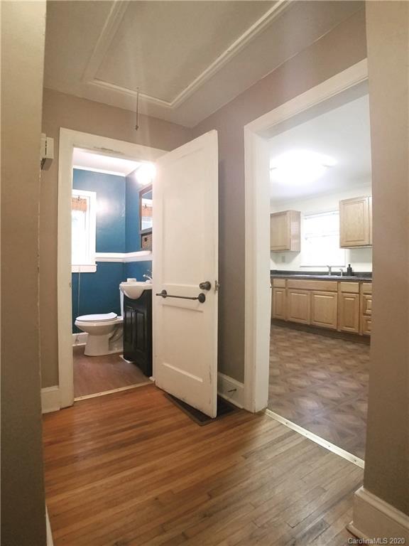 1900 Arnold Drive Charlotte, NC 28205 - Photo 10 of 23 a view of a kitchen and an empty room with wooden floor