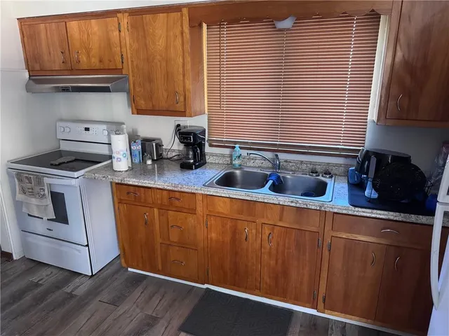a kitchen with stainless steel appliances granite countertop a sink a stove and cabinets