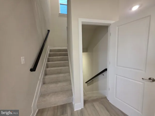 a view of staircase with white walls and railing