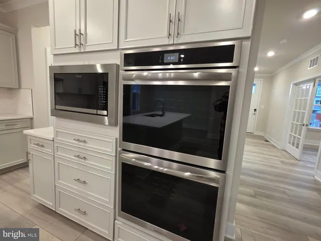 a kitchen with granite countertop white cabinets and stainless steel appliances