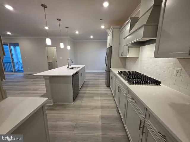 a large kitchen with kitchen island a sink stove and a refrigerator