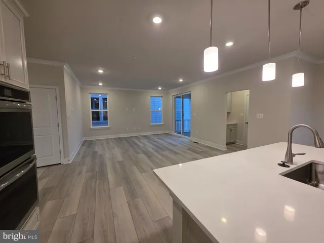 a large kitchen with kitchen island a sink dishwasher a stove and a refrigerator with wooden floor