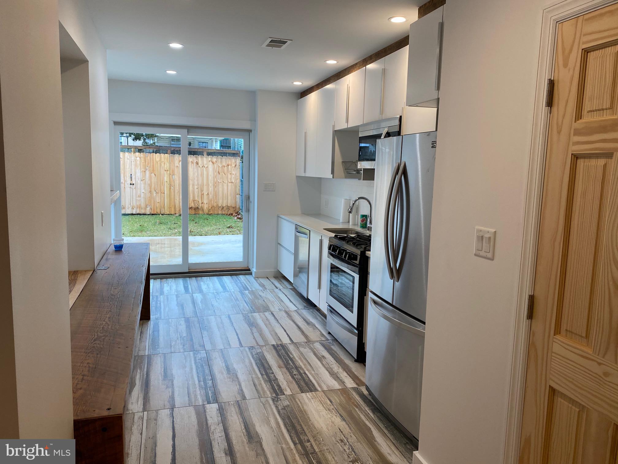 3229 Chatham Street Philadelphia, PA 19134 - Photo 12 of 41 a kitchen with kitchen island wooden floors appliances and cabinets