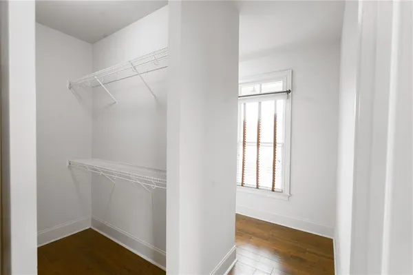 a view of a big room with wooden floor and windows