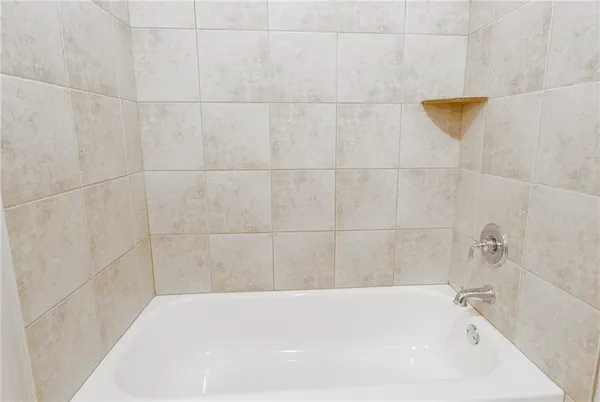 an empty room with wooden floor chandelier fan and windows