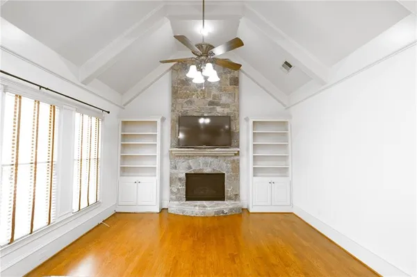 a view of an empty room with a fireplace and a window