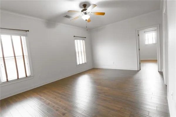 an empty room with a ceiling fan and window