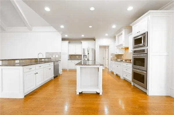 a kitchen with granite countertop cabinets stainless steel appliances and a window