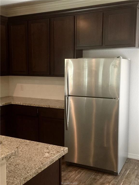 109 Ehlinger Drive Bryan, TX 77801 - Photo 18 of 25 a kitchen with kitchen island a refrigerator and wooden floor