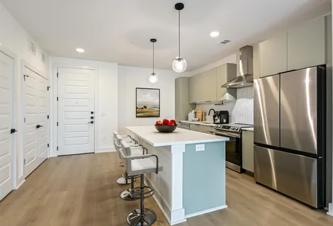a kitchen with kitchen island a refrigerator a stove a sink and a refrigerator