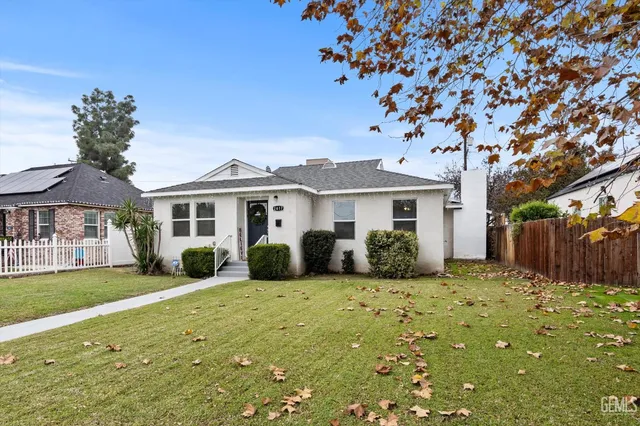 a front view of a house with a garden and yard