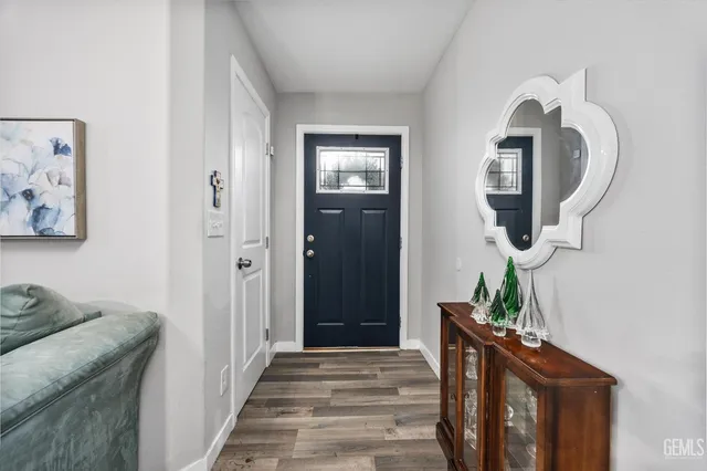 a hallway with front door wooden floor and windows