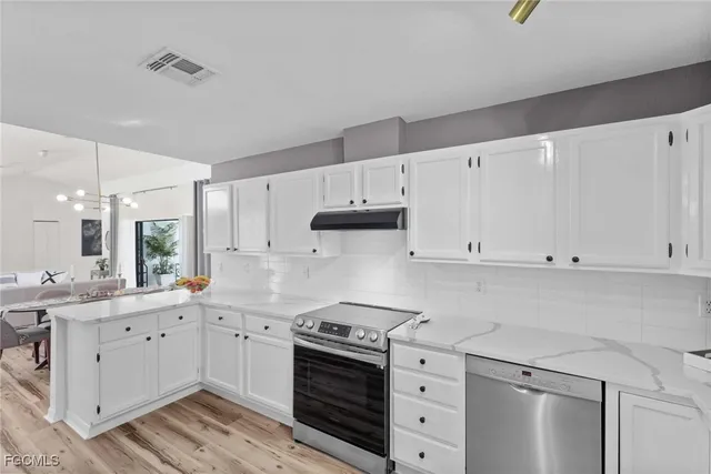 a kitchen with cabinets appliances a sink and a window