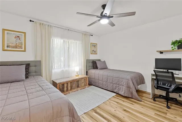 a bedroom with a large bed a chandelier and a window