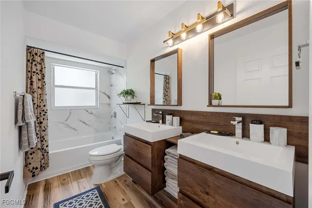 a bathroom with a sink toilet a mirror and bathtub